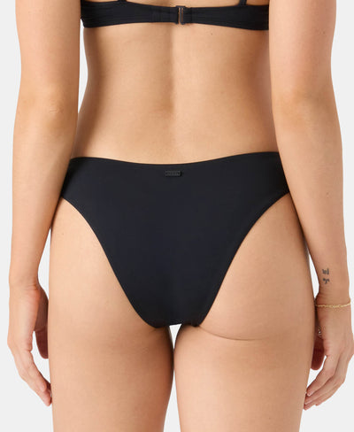 A person wearing a black bikini bottom and matching top, shown from the back. The background is plain, and there is a small tattoo and a bracelet visible on the left arm.