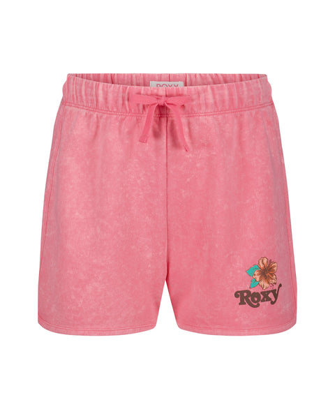 The Roxy Girls' Sunset Short features pink French terry fabric with a faded texture, a small hibiscus flower, and the ROXY Sunset Short logo on the left leg.